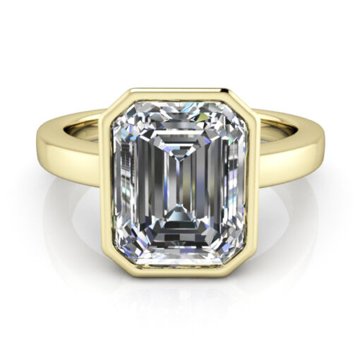 Bezel set emerald cut solitaire ring in yellow gold.